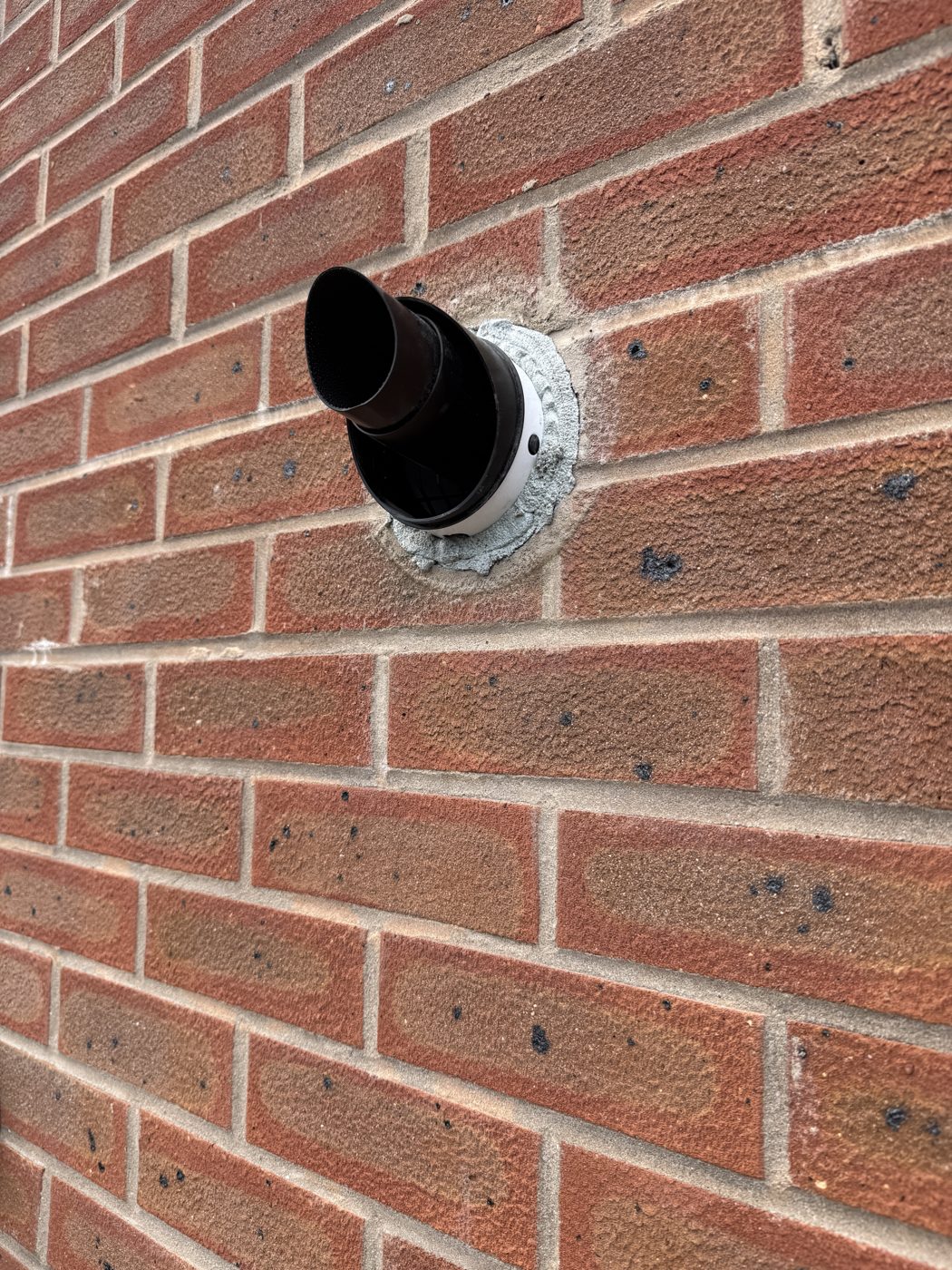 New boiler flue terminal through a brick wall, sealed and finished